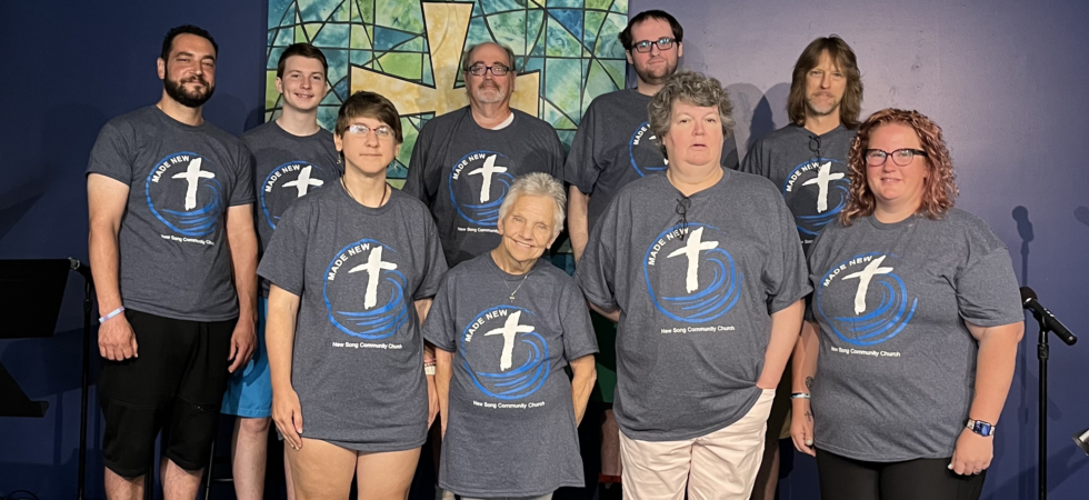 Church members who were baptized pose for picture on front stage of church